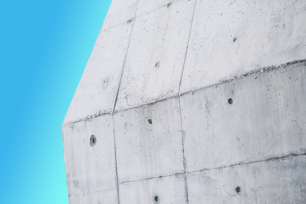 Concrete architectural surfaces meeting at a sharp angle against open sky.